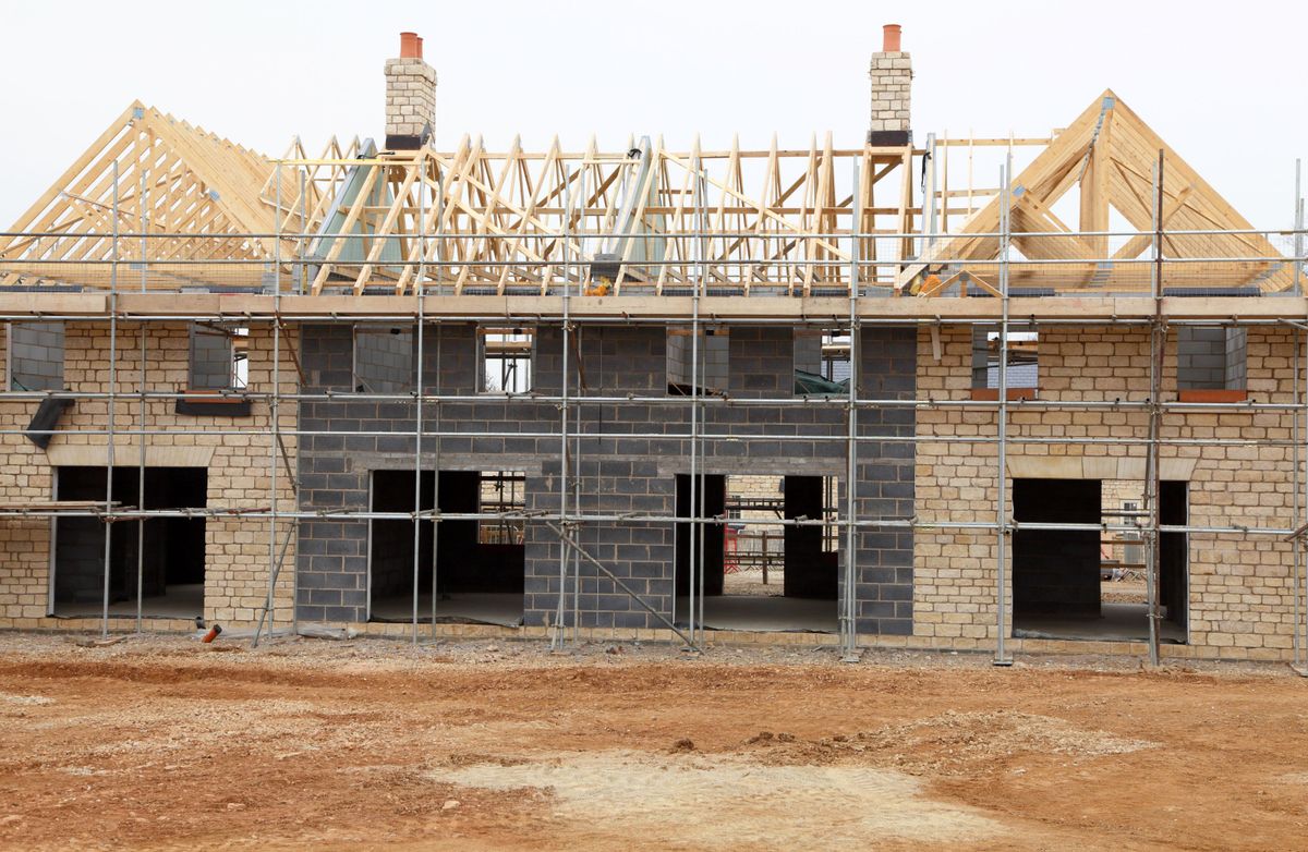 An unfinished home with brick walls and scaffolding