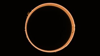 a dark black circle covers most of the sun, leaving just a bright orange ring around its edges