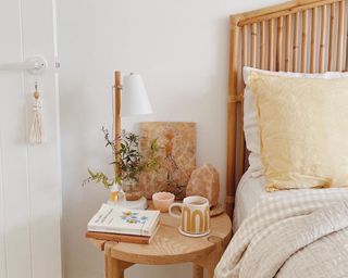 a calm boho nightstand next to a bed with white and yellow sheets
