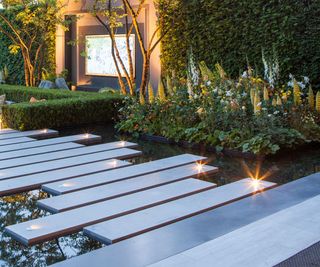 Spotlights built into a stepped pathway across a waterfeature