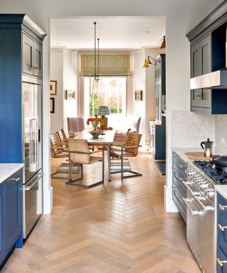 kitchen with blue cabinets and parquet floor and dining area with brown leather dining chairs and wooden table