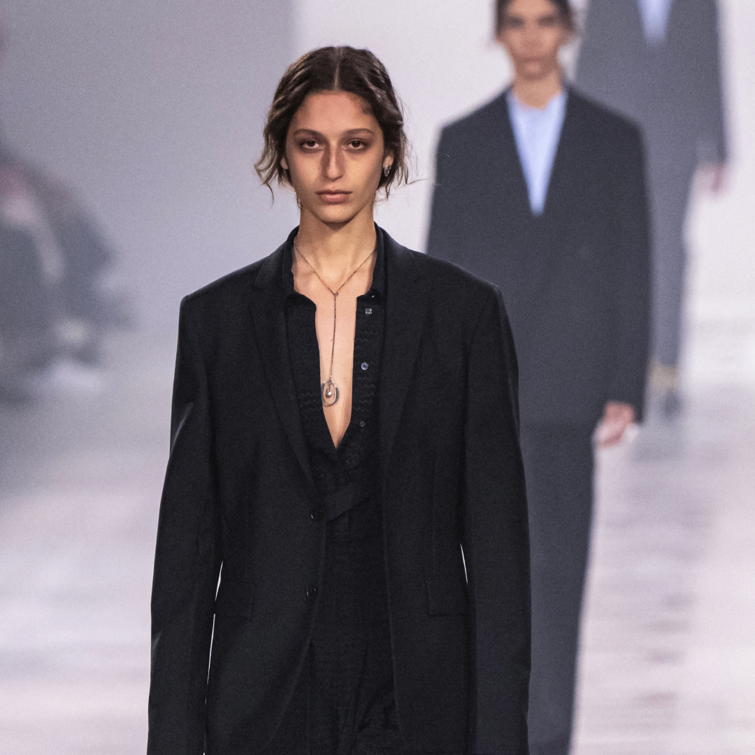 a model walks the Fendi runway wearing a pendant necklace beneath a black shirt