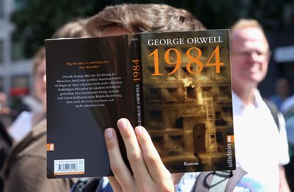A German protester pointedly holds up a copy of 1984.