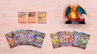 Charizard statue, cards, and Pokemon card booster packs laid out on a wooden surface
