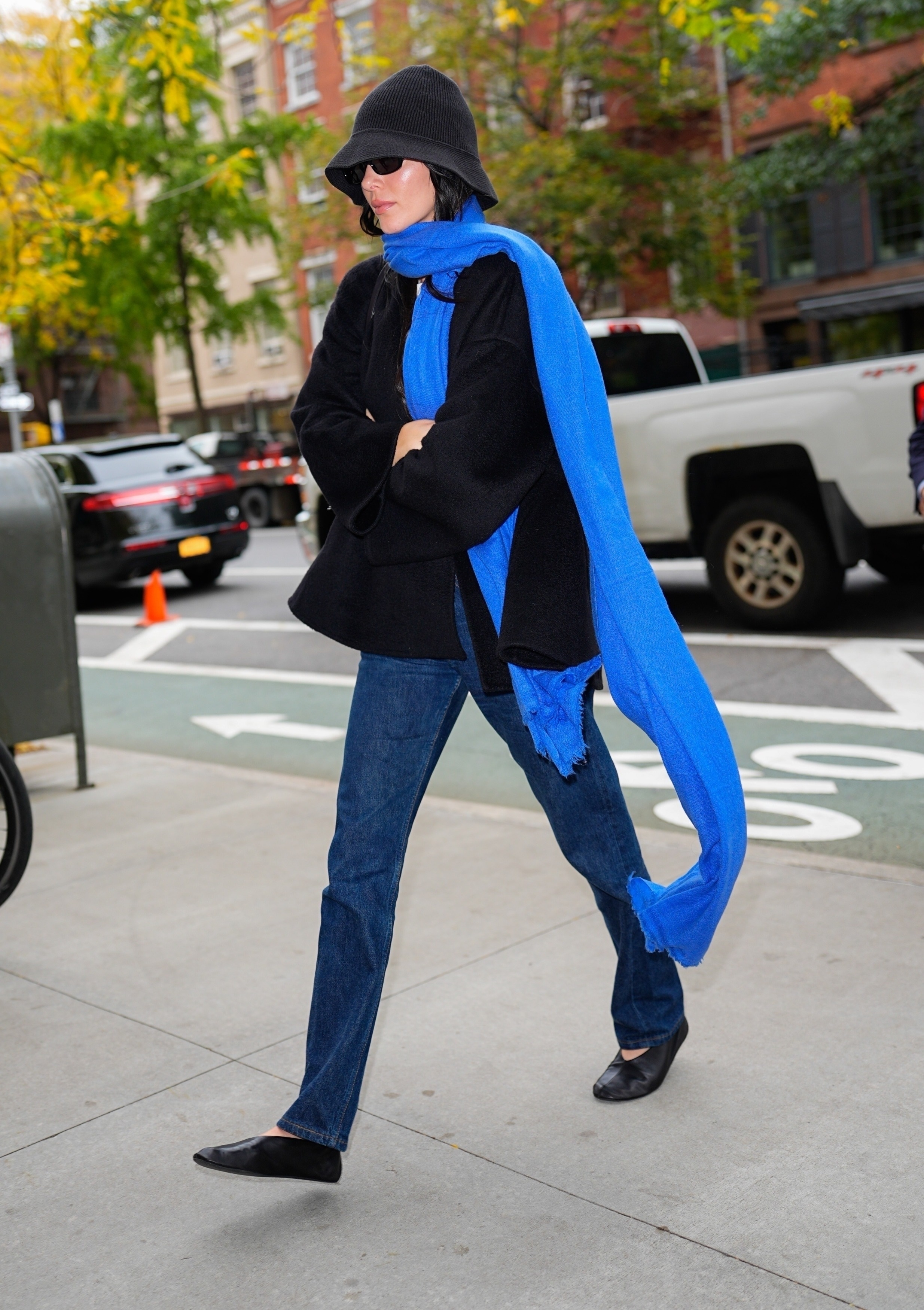 Kendall Jenner wears a knit hat from The Row, a cobalt blue scarf, a collarless jacket, blue jeans and ballet flats while out in the West Village.