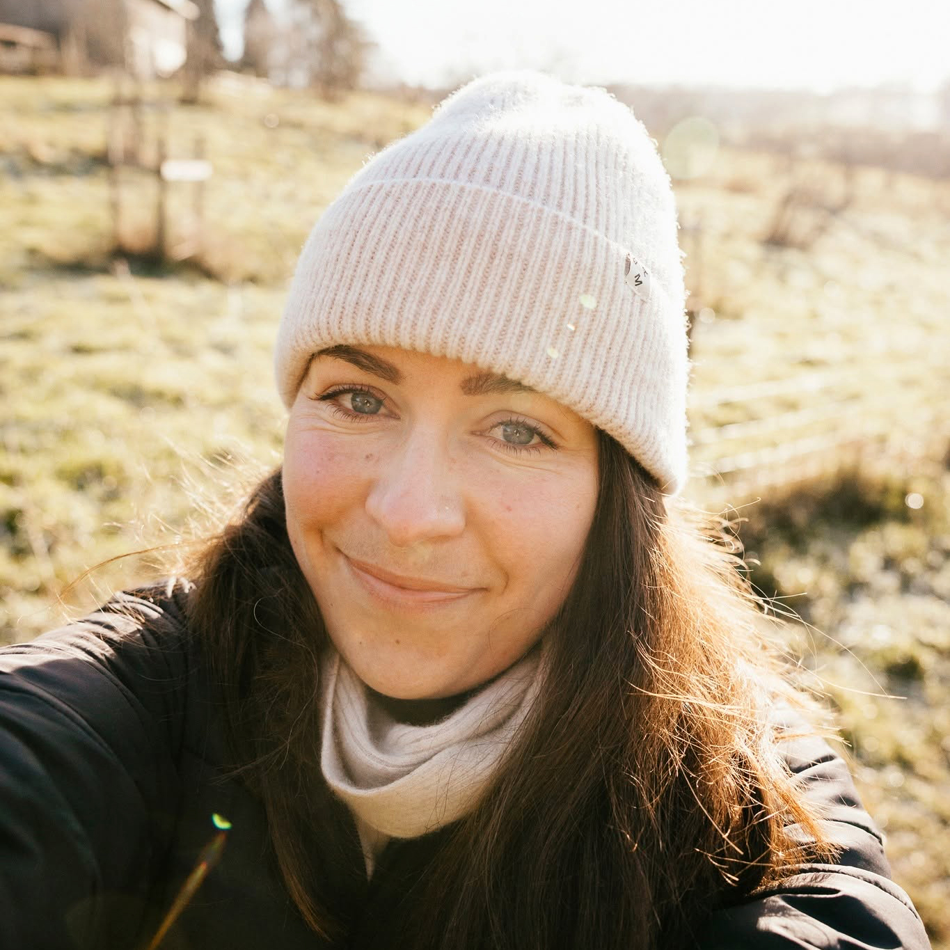 A headshot of freelancer Lauren Scott in a sunny field