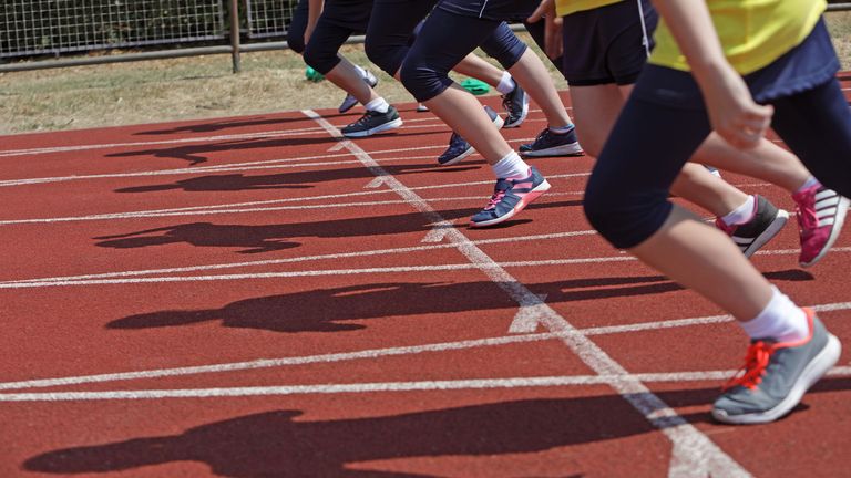 A line of people about to start a race on an athletics track