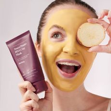 A woman wearing a sweet potato BHA clay mask from Soko Glam.