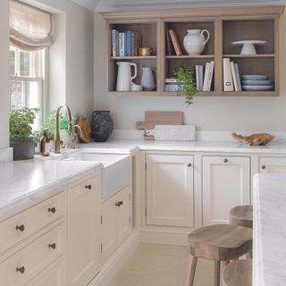Cream kitchen with wooden shelving and stools