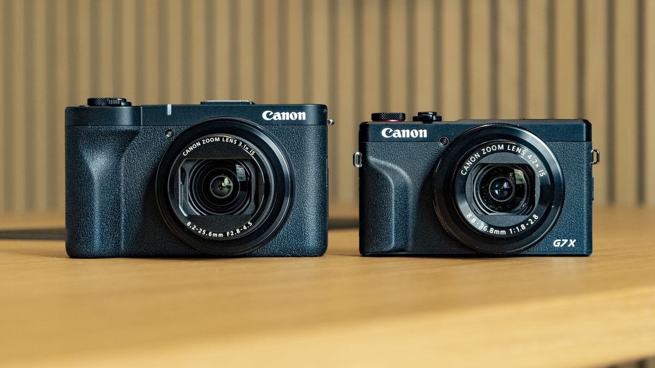 Canon PowerShot V1 compact vlogging camera on a wooden desk alongside the PowerShot G7X Mark III
