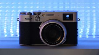 Fujifilm X100VI camera in front of a blue neon light