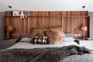 Bed with cedar headboard and pendant lights with wood shades