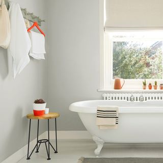 bathroom with grey wall bathtub and window