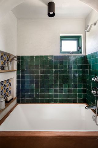 A bathroom with a wooden bathtub, and Moraccan tiles