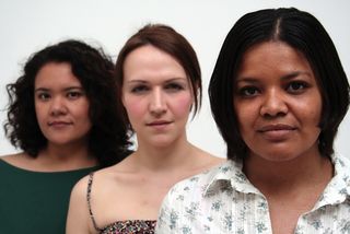 Three women stand together, one looks Hispanic, one looks white, and one looks black.