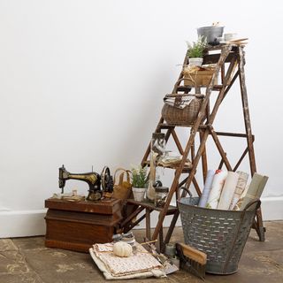 wooden ladder shelve white wall and sewing machine