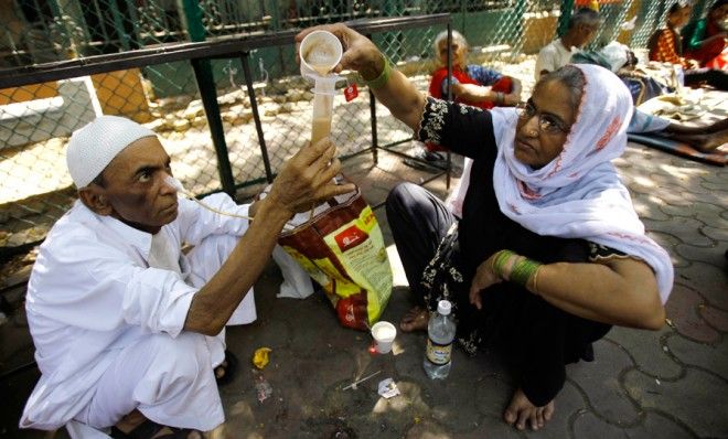 A 68-year-old man suffering from throat cancer gets help outside a cancer hospital in Mumbai on April 1.