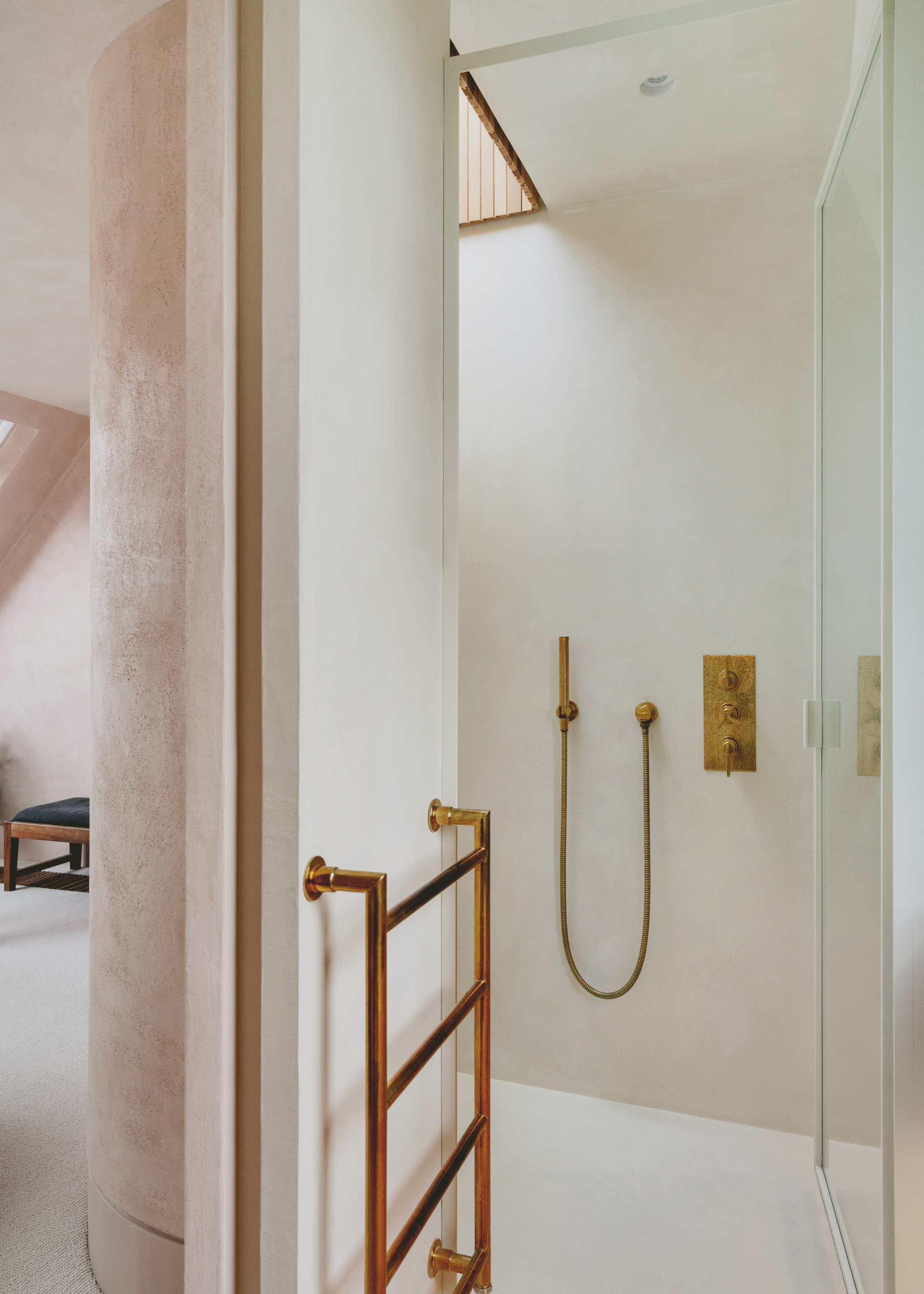 at the intersection of the bedroom and the ensuite, a rounded wall provides home for a semicircular shower