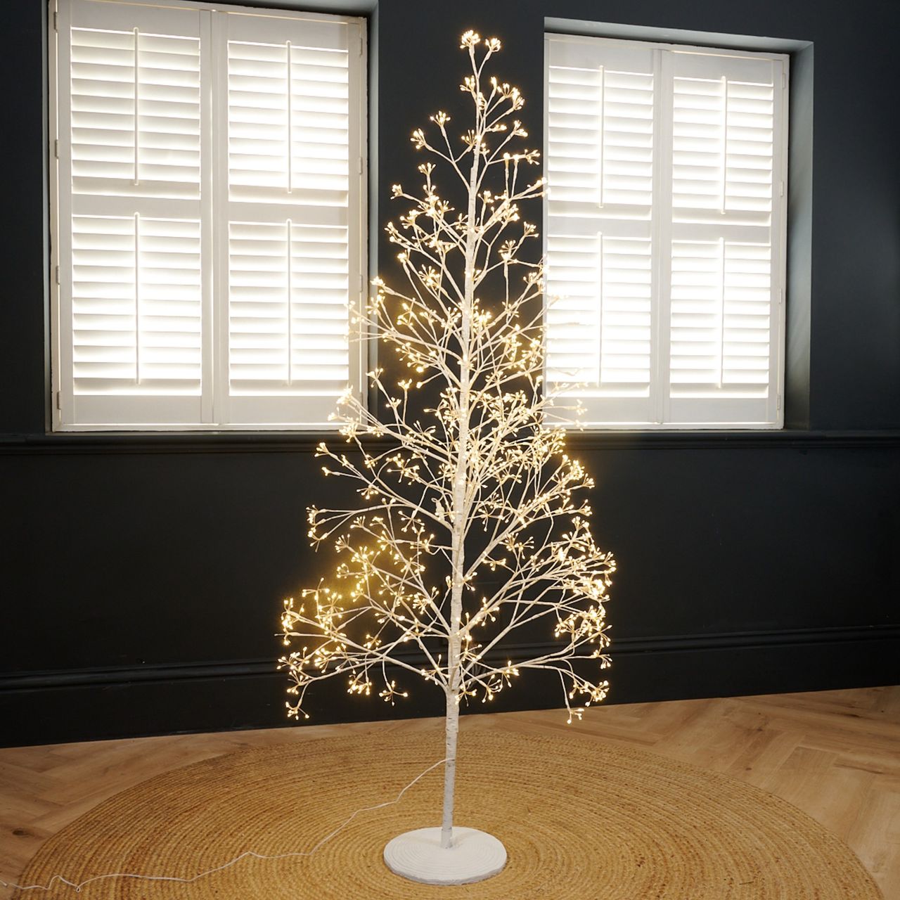 Next's White Twig 6ft Pre Lit Christmas Tree set up in a black-painted living room