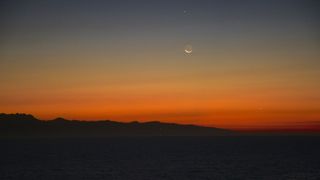A waning crescent Moon showing ‘Earthshine’ with Jupiter and Mercury from the Azamara Journey, California coast