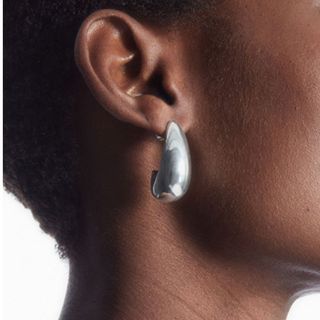 Cropped image of woman wearing silver earrings