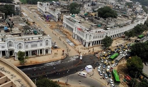 Traffic and commuters are seen stuck at an intersection as cyclists (L) ride in a pack through Connaught Place in New Delhi.