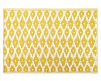A colourful bright yellow outdoor rug with a ikat diamond pattern
