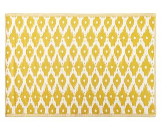 A colourful bright yellow outdoor rug with a ikat diamond pattern