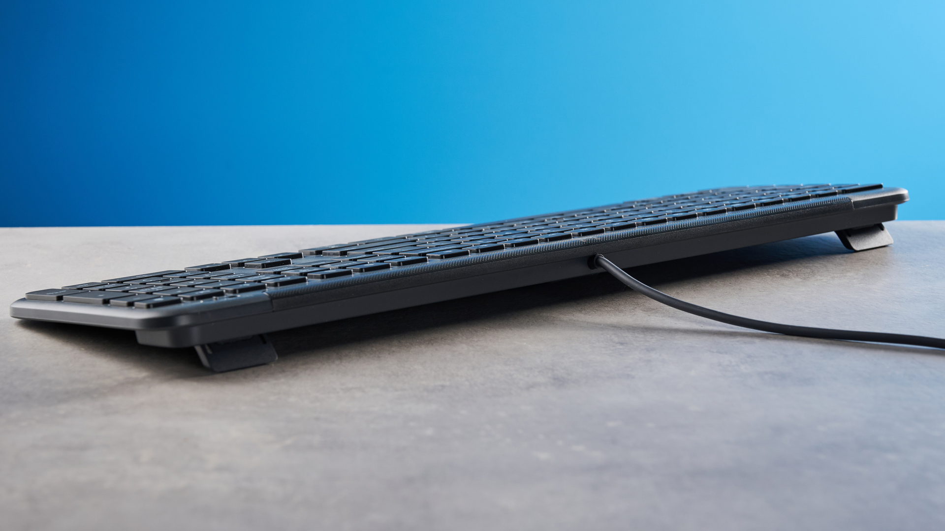 The Logitech K620 keyboard in a graphite grey colorway photographed as part of the MK625 como on able and white background.