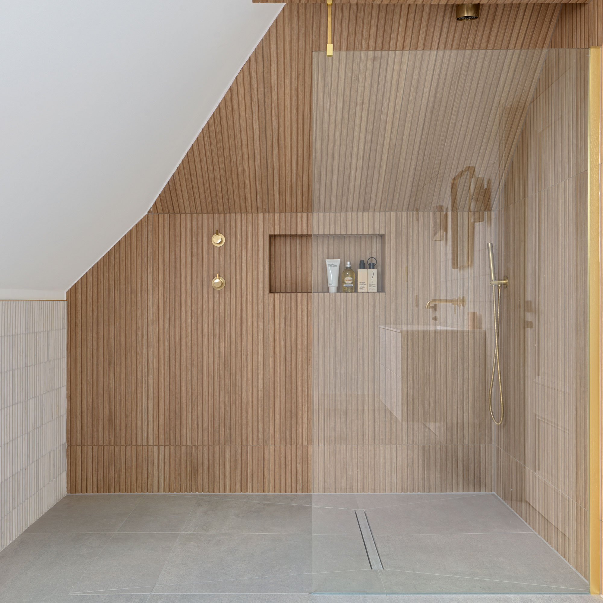 Wood panelled shower with tanked floor and glass partition