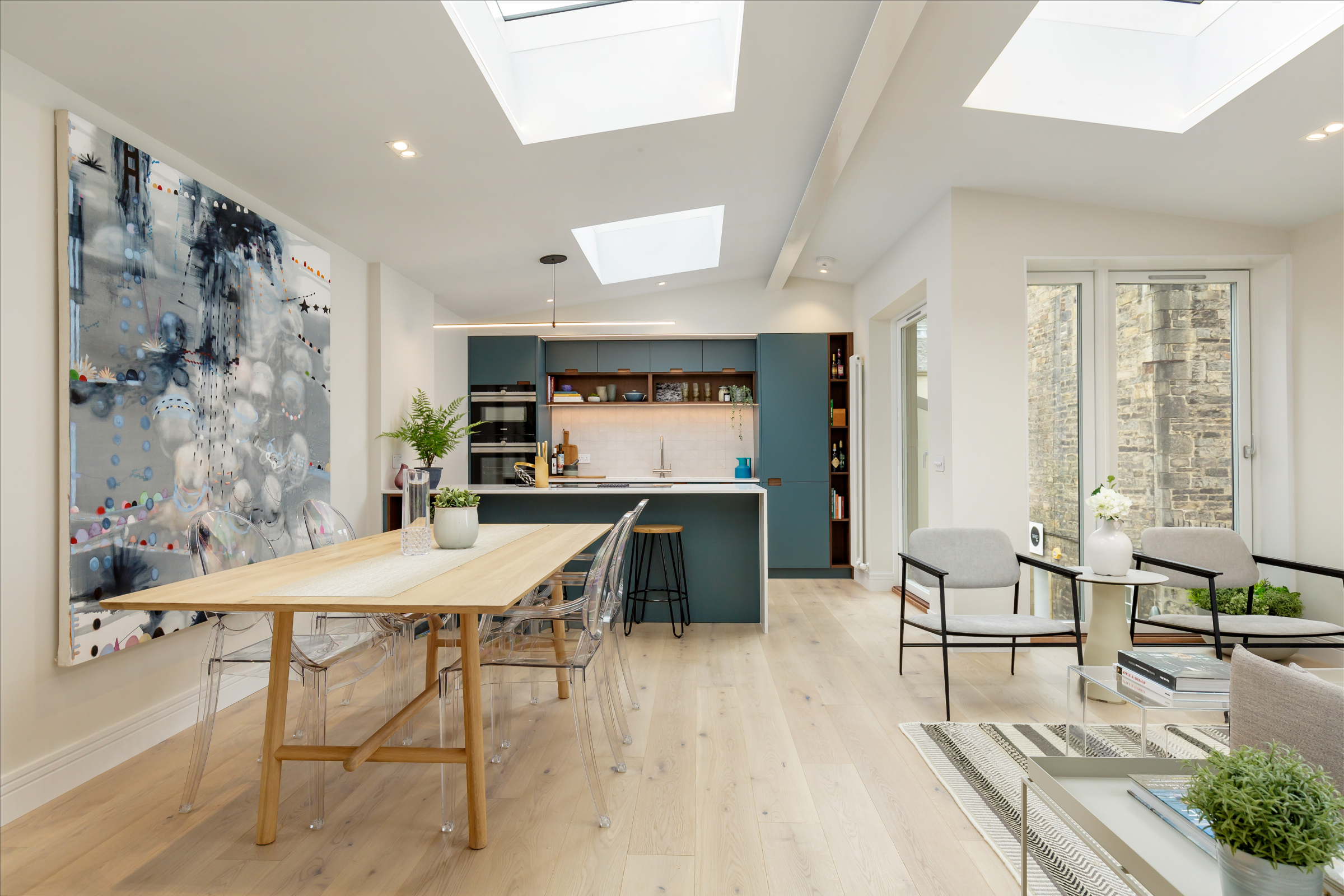 open plan kitchen living and dining space with light wooden floor, long dining table