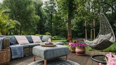 Patio furniture on decking with planters and trees in background