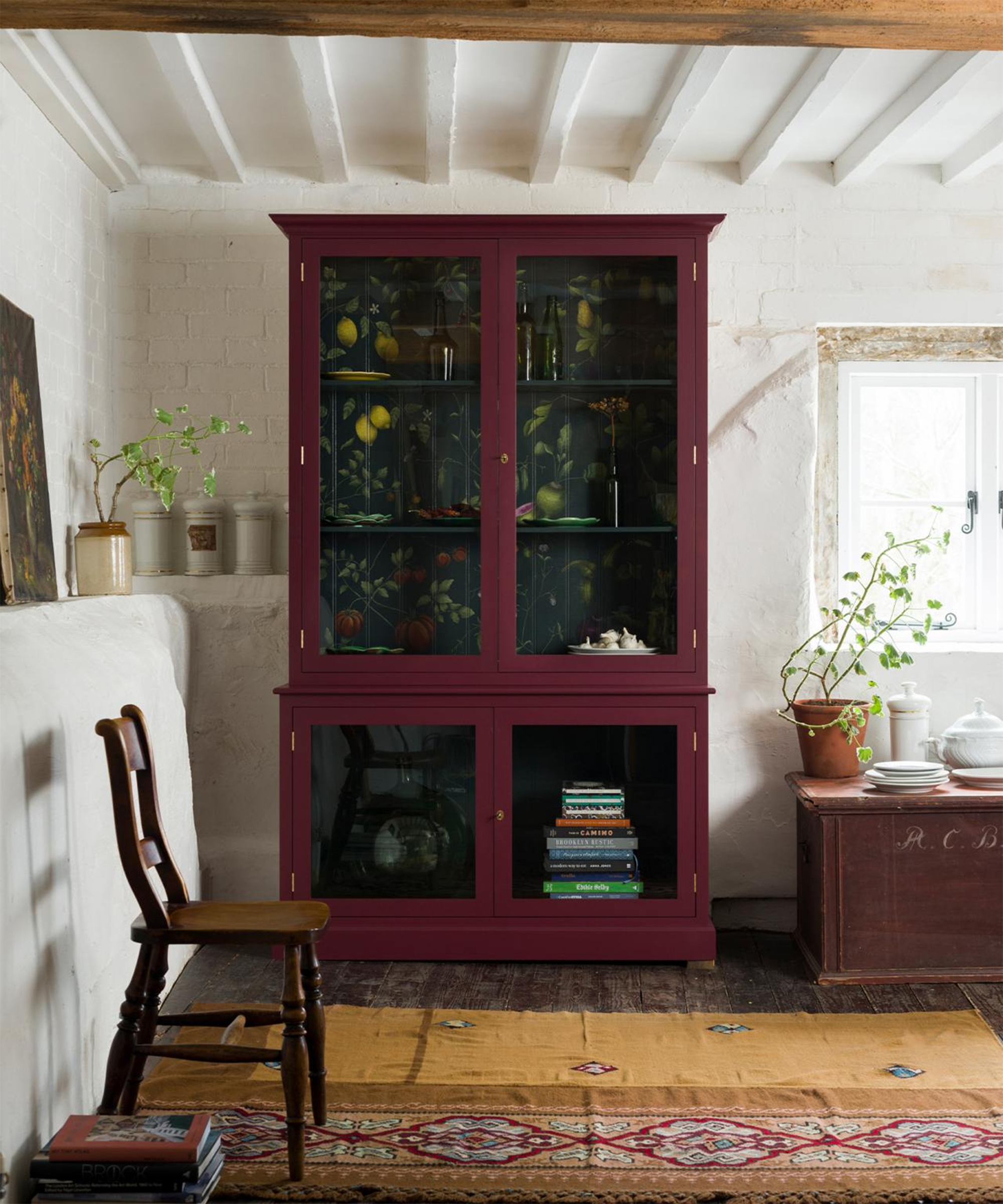 A red kitchen dresser cabinet with black and floral patterned detail in interior