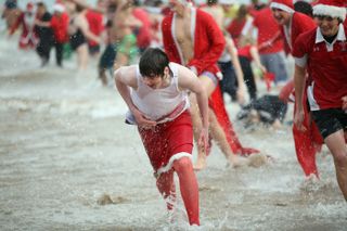 Festive revelers take part in the Tenby Big Red Boxing Day Dip