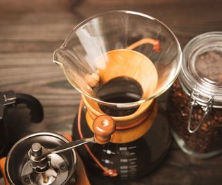 A pour-over coffee maker with a grinder and kilner jar of coffee beans