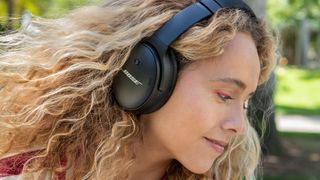 Bose QC45 headphones worn by a woman.