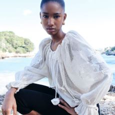 Woman wearing FARFETCH top and trousers on beach