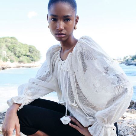 Woman wearing FARFETCH top and trousers on beach