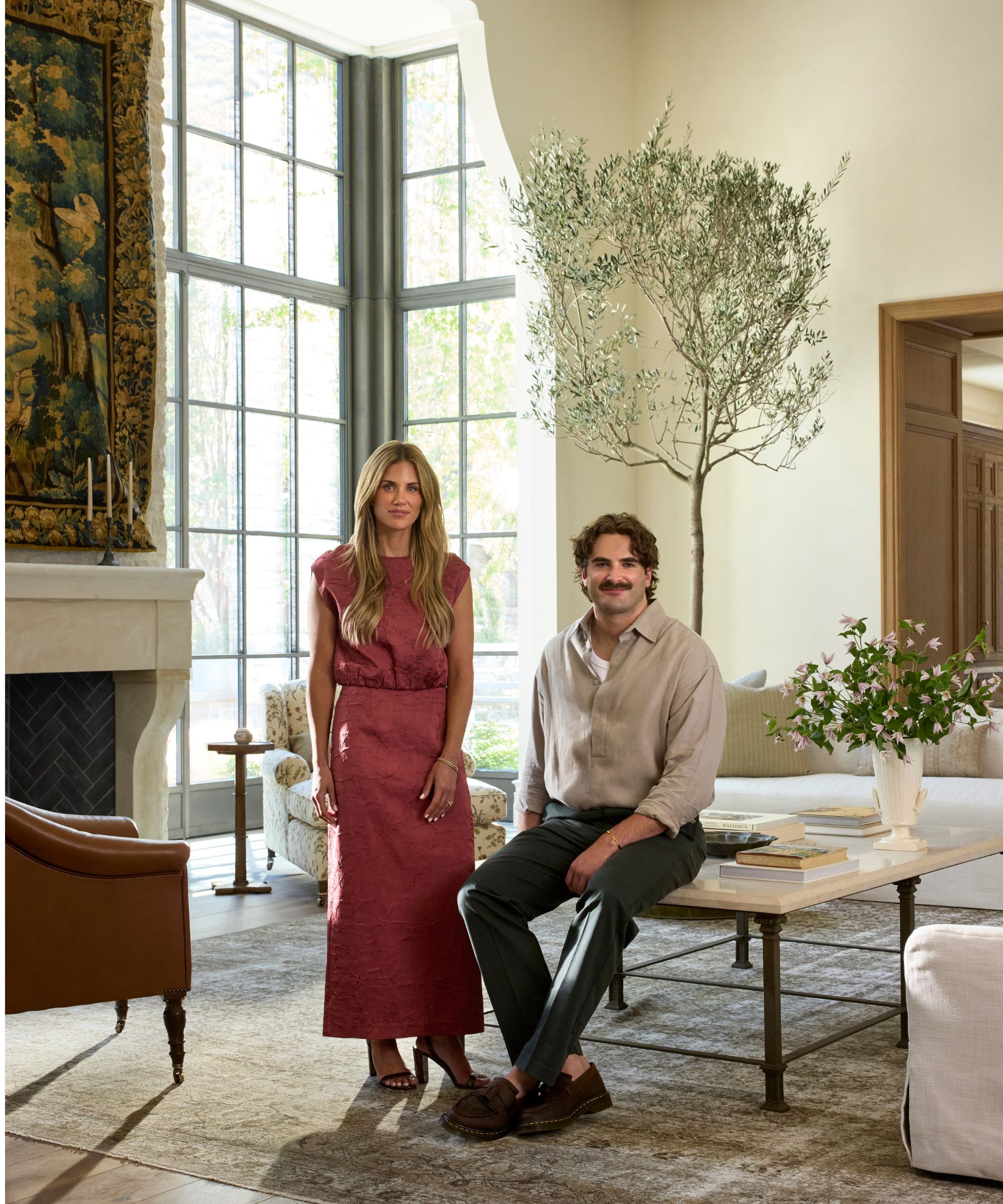 designer Shea McGee and architect Colton Broadbent photographed in a new project in Utah beside a fireplace with a tapestry