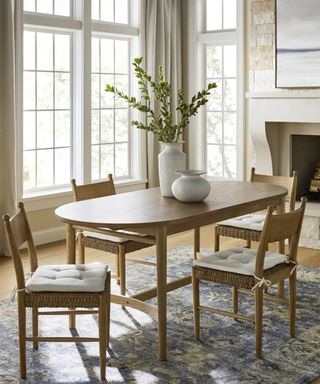 Wooden dining table with rattan chairs and vases