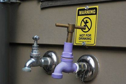 Faucets On Side Of House With Warning Label