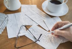 Hand drawing calculations on paper napkin.