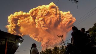 A giant ash plume from Mount Lewoboti Laki-laki in Indonesia. The ash appears orange.