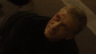 A scarred Christoph Waltz looks up menacingly in Spectre.