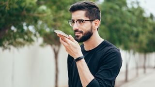 A person speaking into a smartphone.