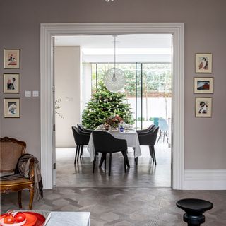 Open living area with a large green Christmas tree next to a dining table decorated with flowers and cutlery