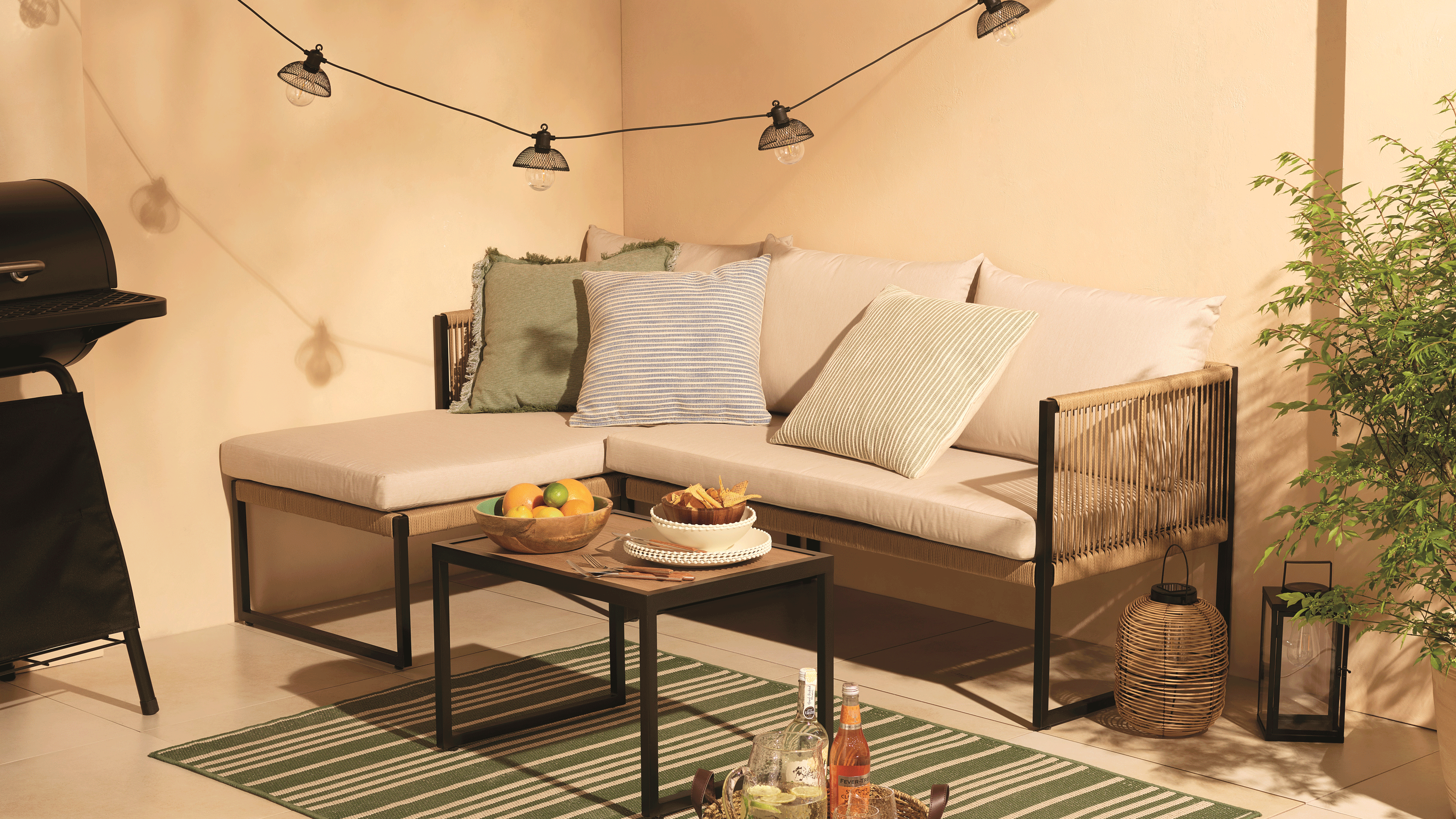 Tesco garden furniture corner sofa with blue and green cushions against a neutral backdrop