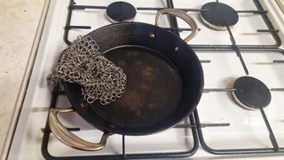 Cast iron being cleaned by a chainmail scrubber