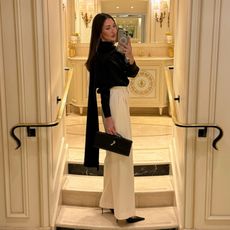 Felicia Akerstrom in a black silk top and white trousers