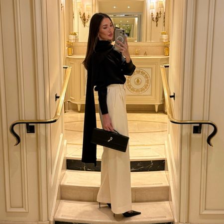 Felicia Akerstrom in a black silk top and white trousers